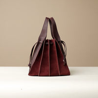 Front view of burgundy Suede Papillon Sr. – pleated suede bucket handbag with leather trim