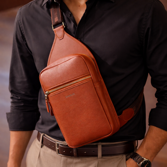 Man wearing a brown leather sling pack Andres over one shoulder.