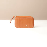 Brown wallet with a visible brand logo on a beige background