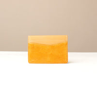 Yellow suede leather Danilos cardholder on a beige background