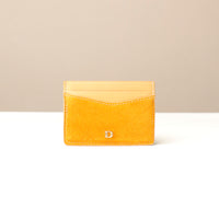 Yellow suede leather cardholder with a Danilos logo on a beige background