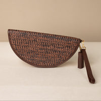 half-circle clutch Agnes made with raffia and palisander, brown leather details, with leather strap and tassel, front view
