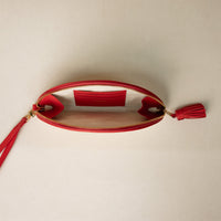 An open clutch Agnes made with raffia rot and red leather details, with leather strap and tassel, with three slots for cards