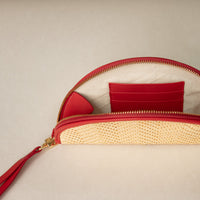 Open clutch Agnes made with raffia rot and red leather details, with leather strap and tassel, gold hardware, upper view