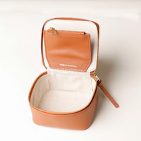 upper view of a small leather Danilos Jewelry Organizer Anushka in brown with a gold zipper and a brown pocket on a white background