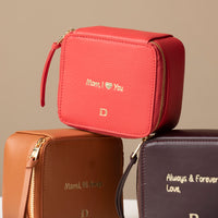 Three small leather Danilos Jewelry Organizer Anushka with embossed text on a beige background