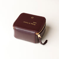 back view of a small leather Danilos Jewelry Organizer Anushka in dark brown with embossed gold text on a white background