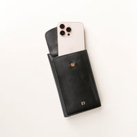 front view of a open black danilos leather multi smartphone alessia with a phone inside a pocket over a white background