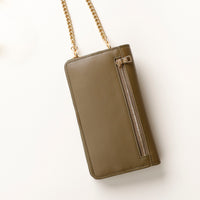back view of a green danilos leather multi smartphone alessia with a gold zipper pocket and chain over a beige background