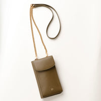 front view of a green danilos leather multi smartphone alessia with a gold zipper pocket and chain with leather combination over a beige background