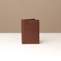 front view of a brown pebble leather passport lovable Danilos on a light surface with a neutral background