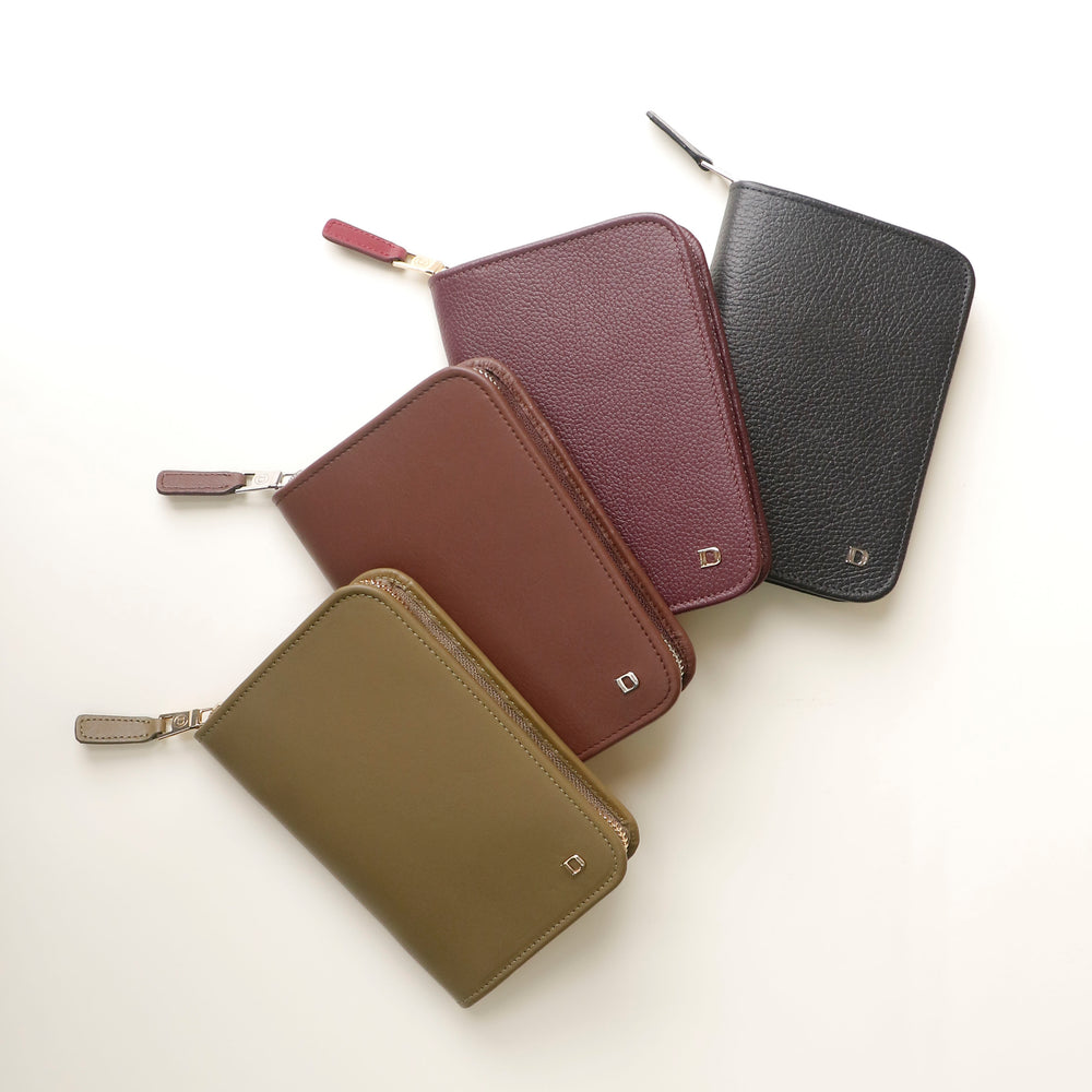 Four leather Danilos passport case lovable in different colors on a white background