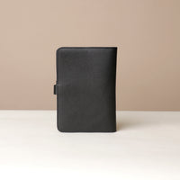Back view of a black Danilos pebble leather inskspirator on a beige background