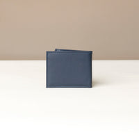behind view of a Blue pebble leather Milano wallet over a beigh background