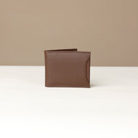 Front of a brown pebble leather Milano wallet with a card case holder slot on the side over a beige background