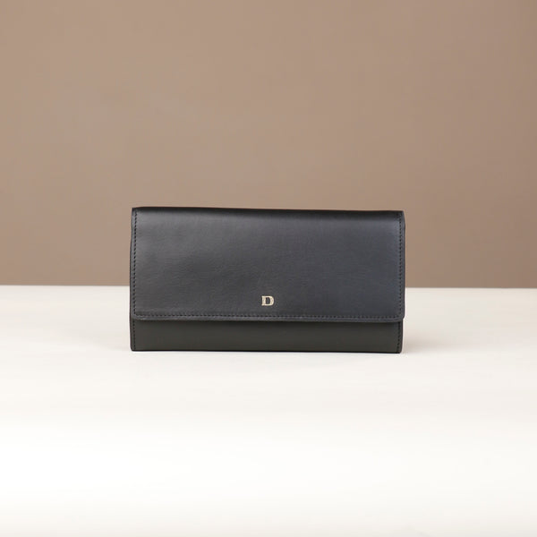 front view of a danilos clucth versaviva in black leather in a beige background