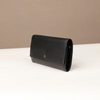 side view of a danilos clucth versaviva in black leather in a beige background