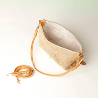 Opened gold crossbody Danilos bag with gold strap on a light background