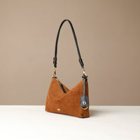 Brown Danilos handbag with black strap on a beige background