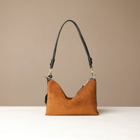 Brown Danilos handbag with black handle on a beige background