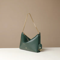 Green Danilos handbag with gold chain strap on a beige background