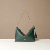 Green Danilos handbag with gold chain strap on a beige background