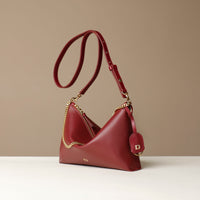 Red Danilos handbag with gold chain detail on a beige background