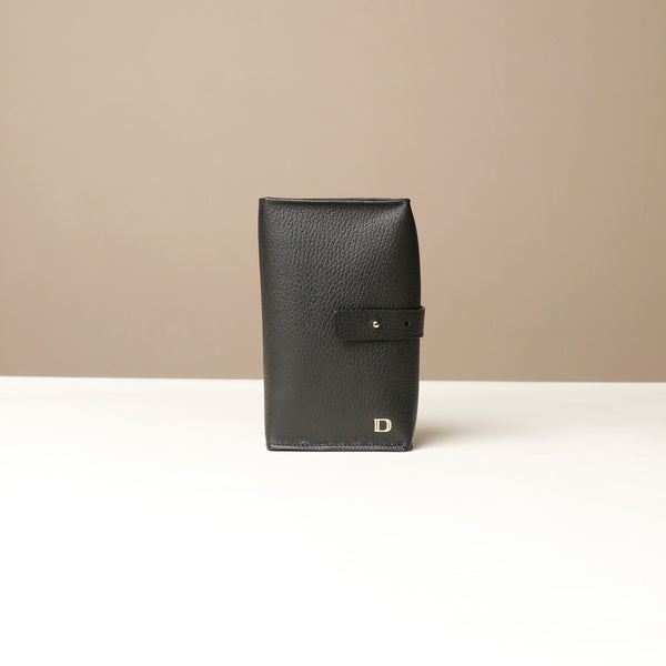 Front view of a black Danilos Pebble executive accessory holder linea on a beige background