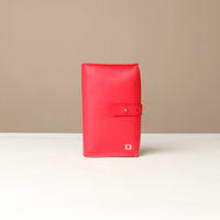 Front view of a red Danilos Pebble executive accessory holder linea on a beige background