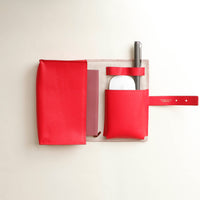 upper view of a oen red Danilos Pebble executive accessory holder linea on a beige background