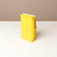 side view of a yellow Danilos Pebble executive accessory holder linea on a beige background