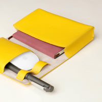 close up view of a open yellow Danilos Pebble executive accessory holder linea on a beige background