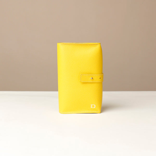 Front view of a yellow Danilos Pebble executive accessory holder linea on a beige background