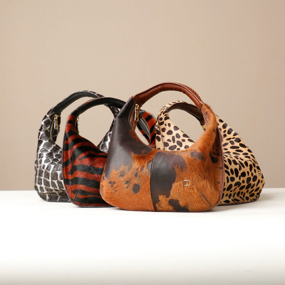 Three Danilos handbags with animal print patterns on a beige background
