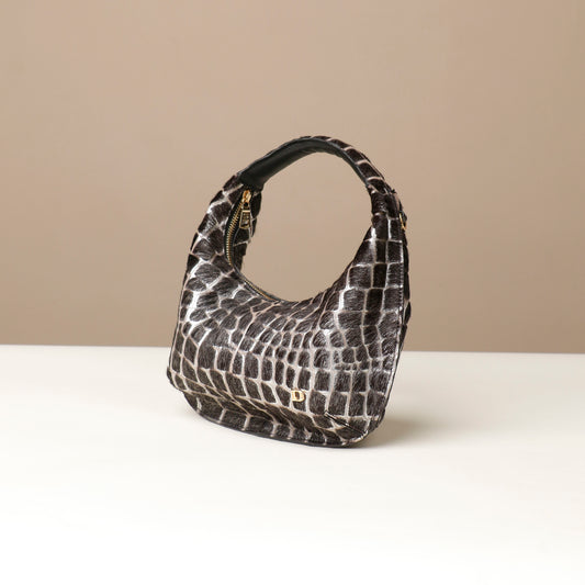 Black and white patterned danilos  handbag on a beige background