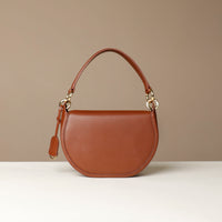 Brown Danilos leather handbag on a beige background