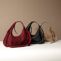 Three Danilos handbags in red, black, and beige on a white surface with a beige background