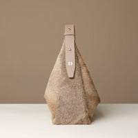 Textured hair on leather Danilos handbag with leather strap on a neutral background