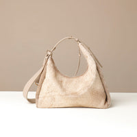 Beige hair on Danilos leather handbag on a white surface with a beige background