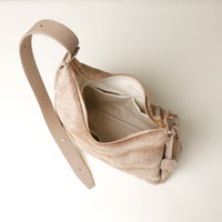 Beige Danilos crossbody opened  bag on a light beige background