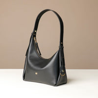 Black Danilos handbag on a beige background and white base