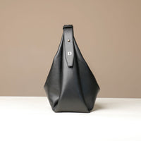 Black leather bag with a visible Danilos logo on a beige background