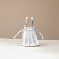 front view of a Danilos Handbag mini papillon junior in metallic silver color leather over a beige background