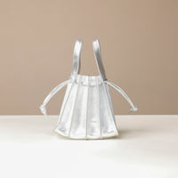 back view of a Danilos Handbag mini papillon junior in metallic silver color leather over a beige background