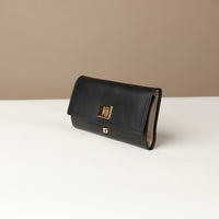 Side view of the Danilos Leather jewelry organizer Mishka in black with gold accents in a beige background
