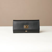 Front view of the Danilos Leather jewelry organizer Mishka in black with gold accents in a beige background