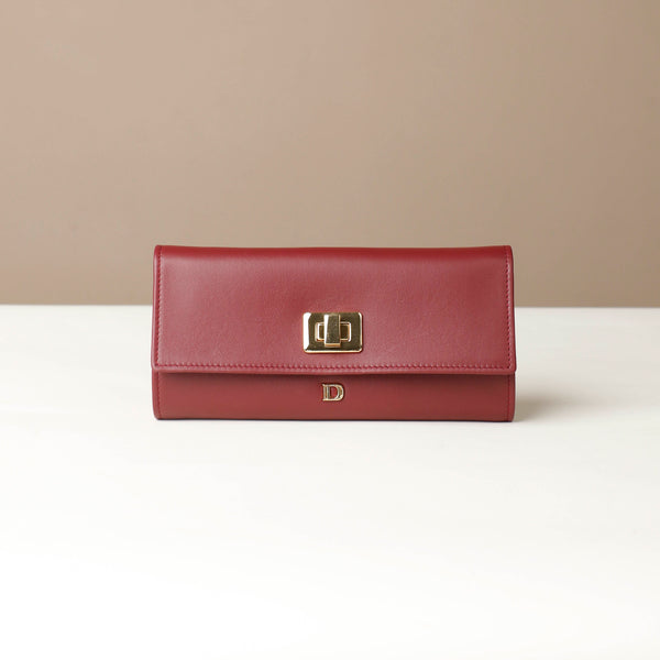 Front view of the Danilos Leather jewelry organizer Mishka in red with gold accents in a beige background