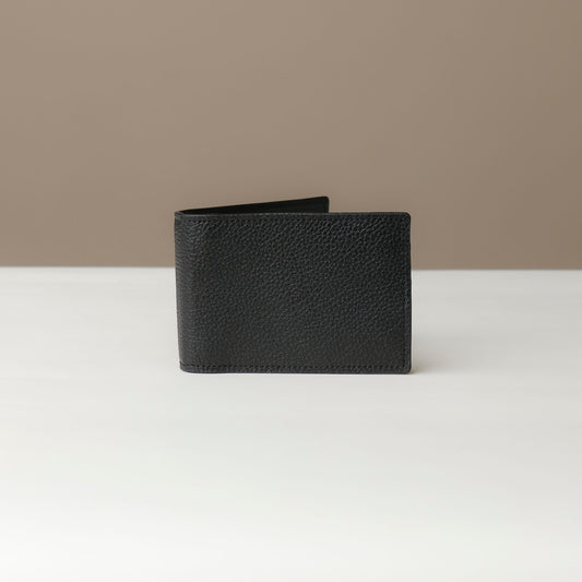 Front view of a Danilos pebble black leather money clip Steven, in a beige and white background