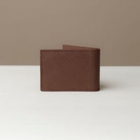 Back view of a Danilos pebble brown leather money clip Steven, in a beige and white background
