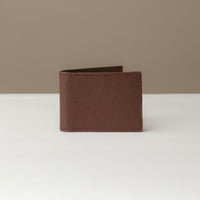 Front view of a Danilos pebble brown leather money clip Steven, in a beige and white background